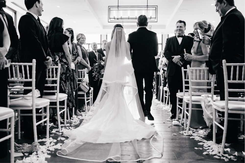 Bride walking down the aisle during an intimate indoor wedding ceremony by Emily Wren Photography