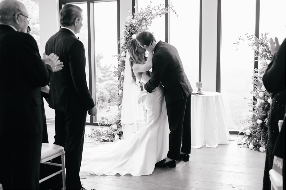 Bride and groom's first kiss during an intimate spring wedding ceremony near Philadelphia