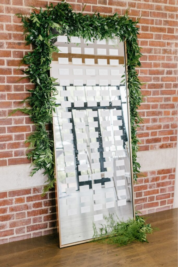 Mirrored seating chart with lush greenery for a cozy spring wedding in NJ
