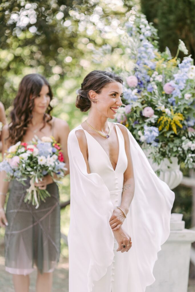 Bride smiling during a summer outdoor wedding ceremony in Italy by Emily Wren Photography
