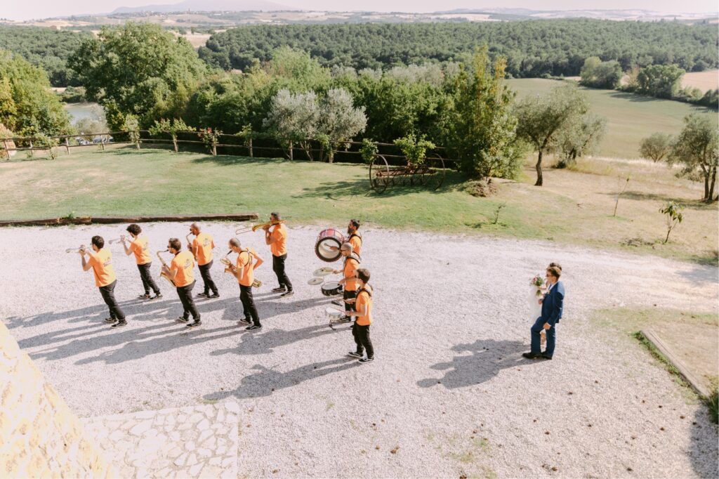 Band leading guests to cocktail hour with the Tuscan landscape behind them