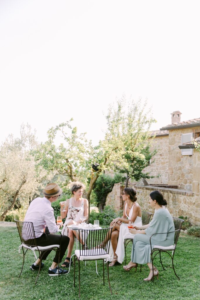 Guests mingling during cocktail hour at an estate in Tuscany by Emily Wren Photography