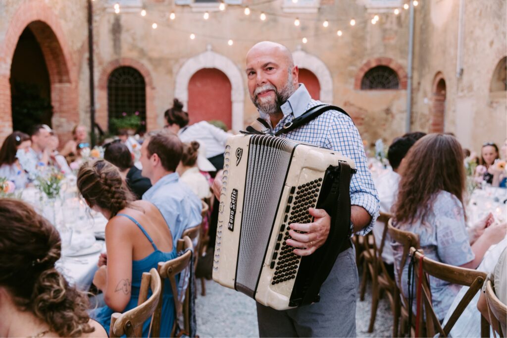Accordian player entertaining guests at an intimate destination wedding in Tuscany