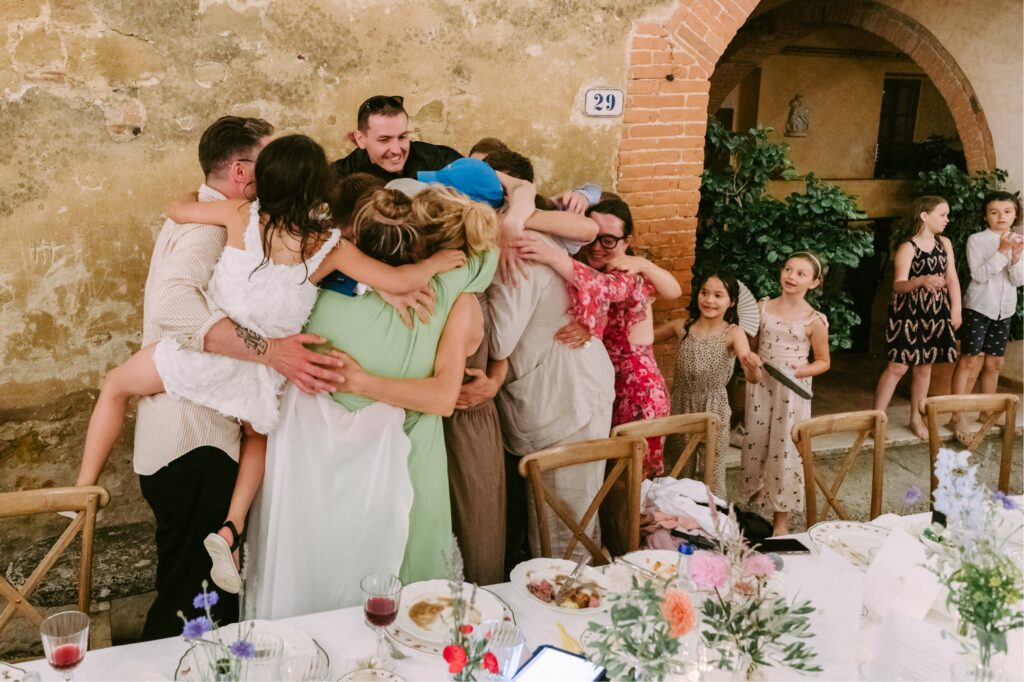 Group hug after a moving wedding toast at an estate wedding in Italy