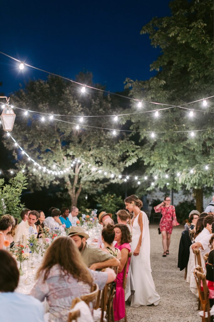 Bride visits with her guests at an outdoor wedding reception in Italy by Emily Wren Photography