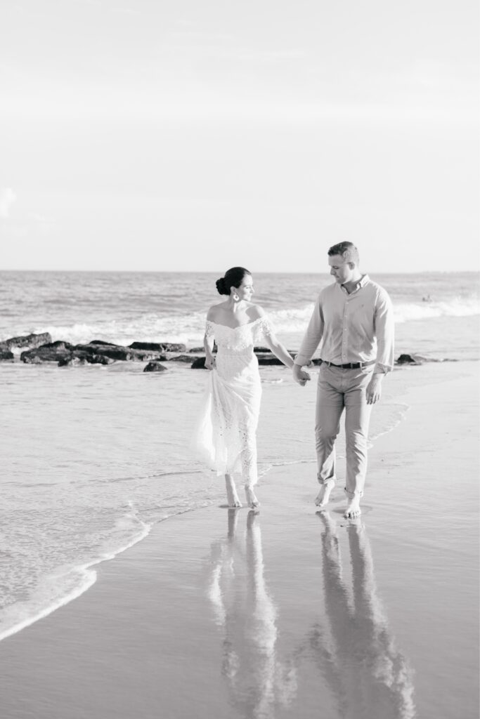 Engaged couple walking along the beach in Sea Isle, New Jersey during an photo session with Emily Wren Photography