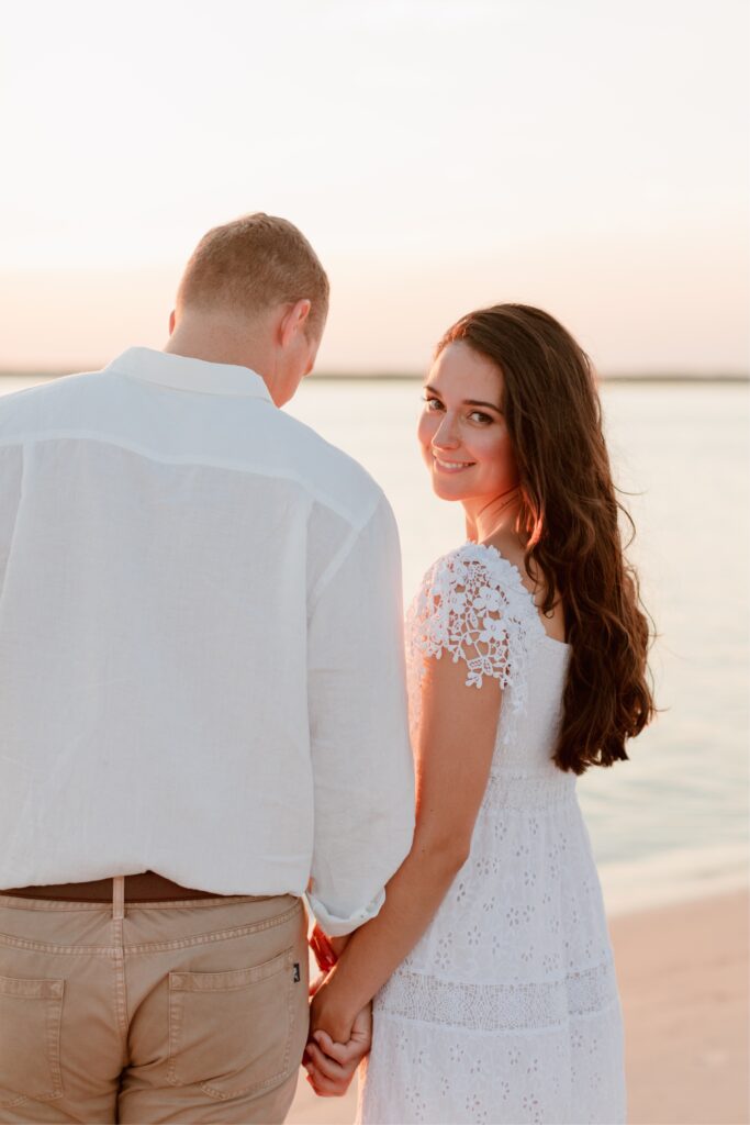 In love couple at sunset during a beach engagement shoot by Emily Wren Photography