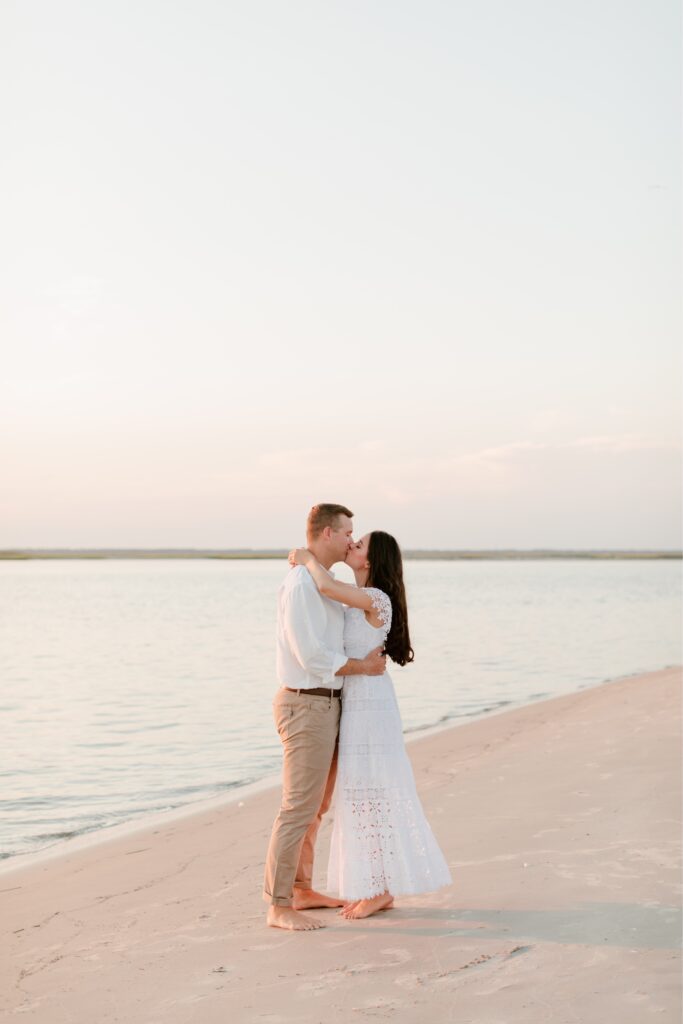 Couple kissing on the beach in New Jersey during a summer engagement session by Emily Wren Photography