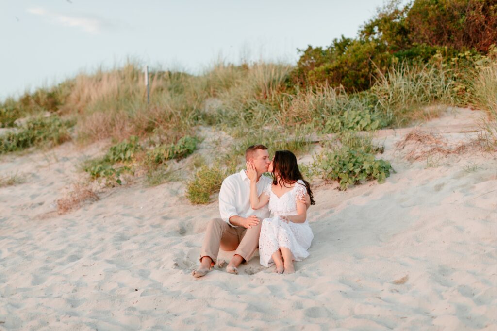 Couple kissing at sunset on the sand dunes at the beach in Sea Isle, NJ
