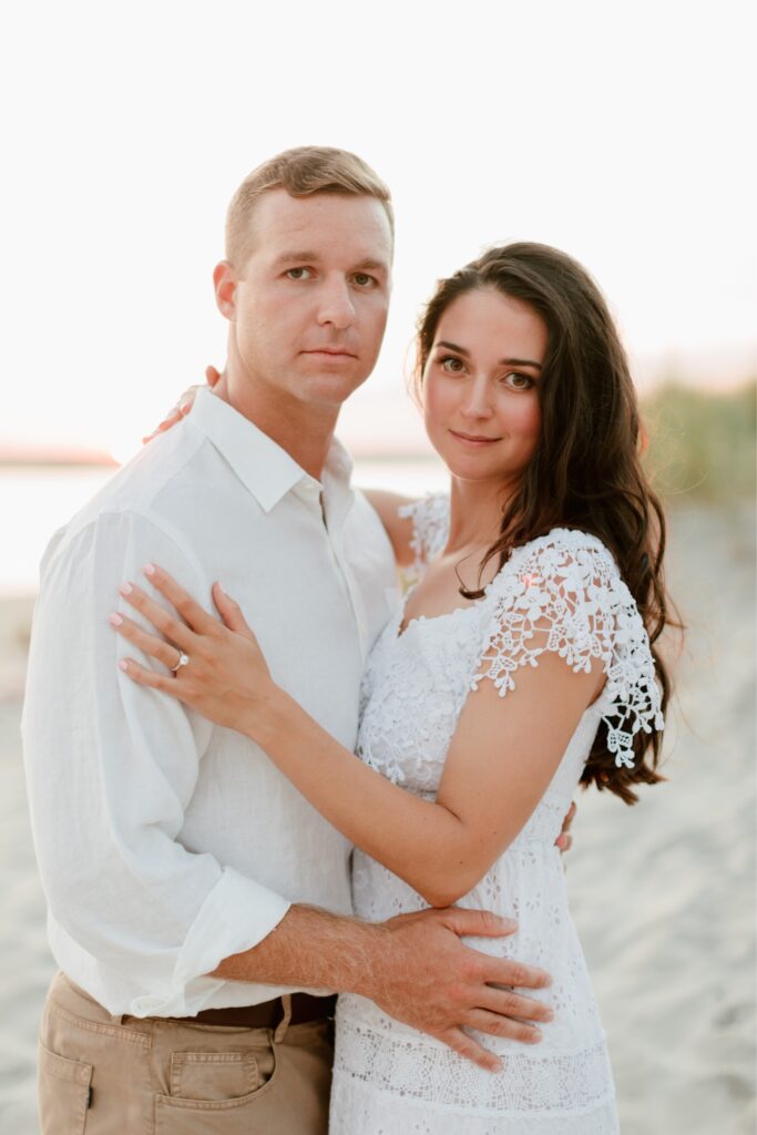 Engaged couple smiling during a sunset portrait session on the beach in Sea Isle