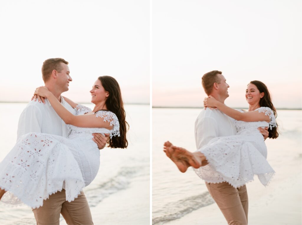 Couple laughing at sunset as the to be groom carries his fiancé along the beach