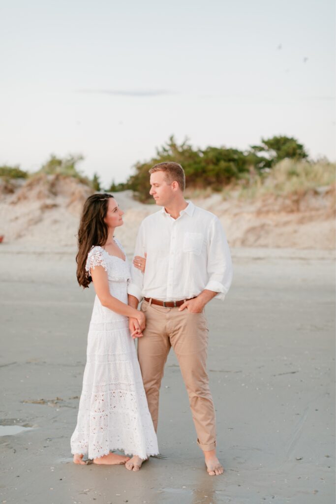 Engaged couple holding hands at sunset on the beach in Sea Isle, NJ