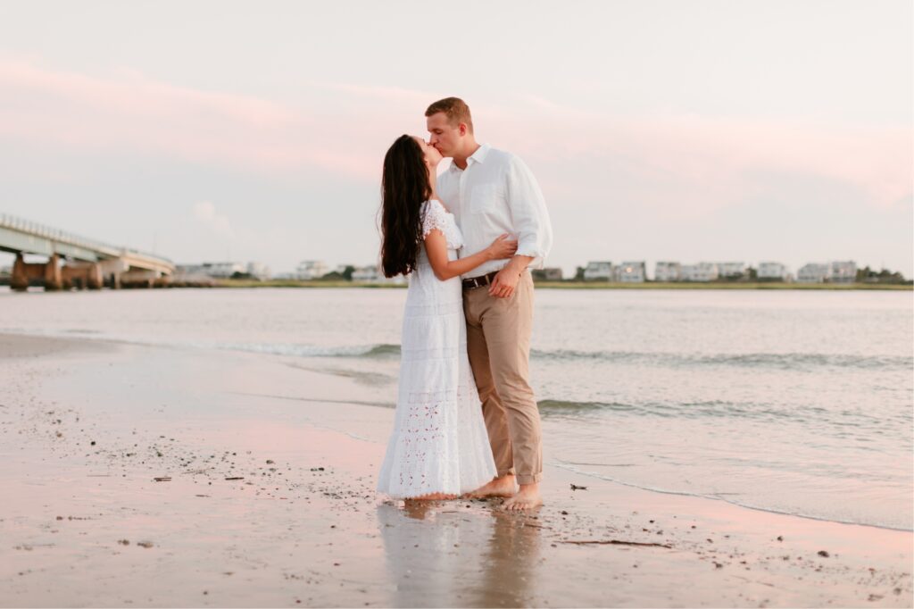 Engaged couple kissing on the beach at sunset in Sea Isle, New Jersey
