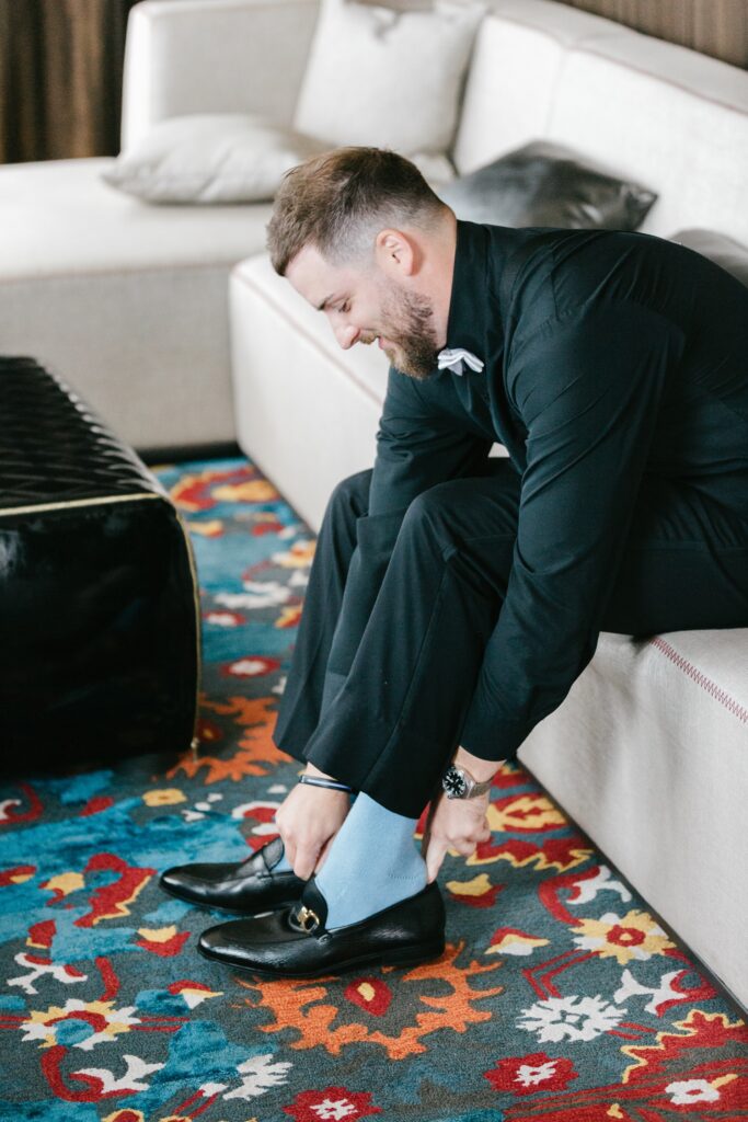A groom putting his shoes on before his Spring Philadelphia wedding