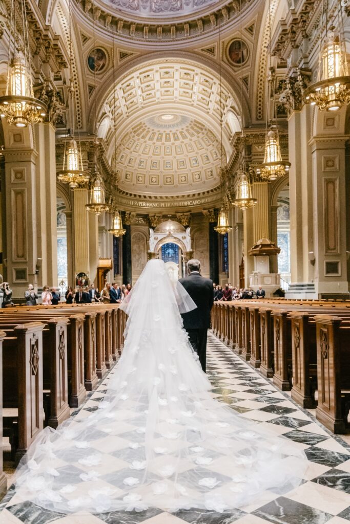 Bride walking down the church aisle with her father in a Philadelphia cathedral