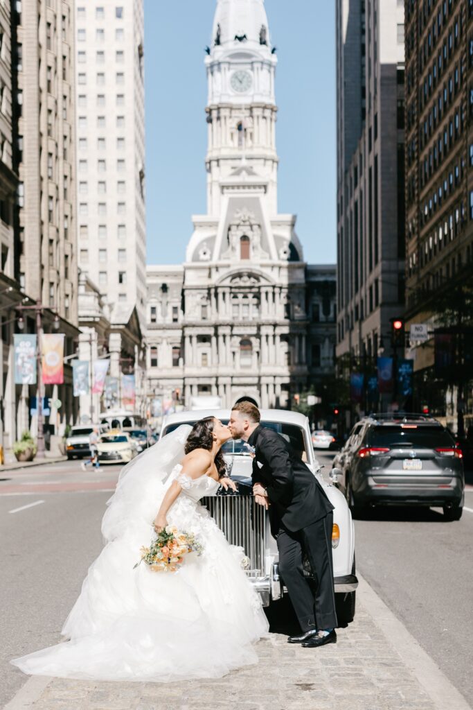 Bride and Groom kissing in front of a Rolls Royce in Center City Philadelphia