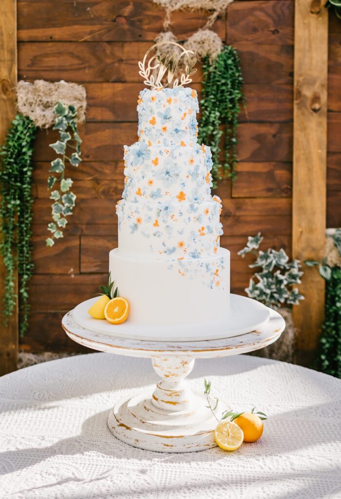 Four tier wedding cake with blue and orange floral details