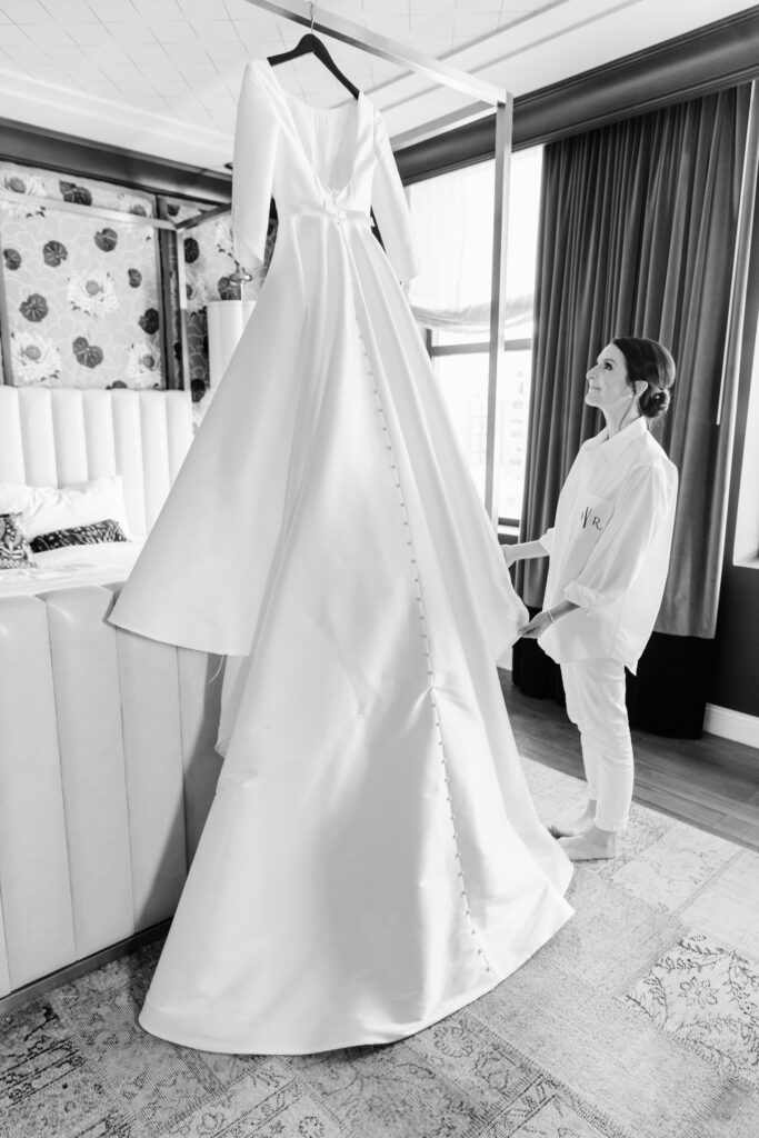 bride admiring her classic, modest wedding dress for her winter wedding in Philadelphia