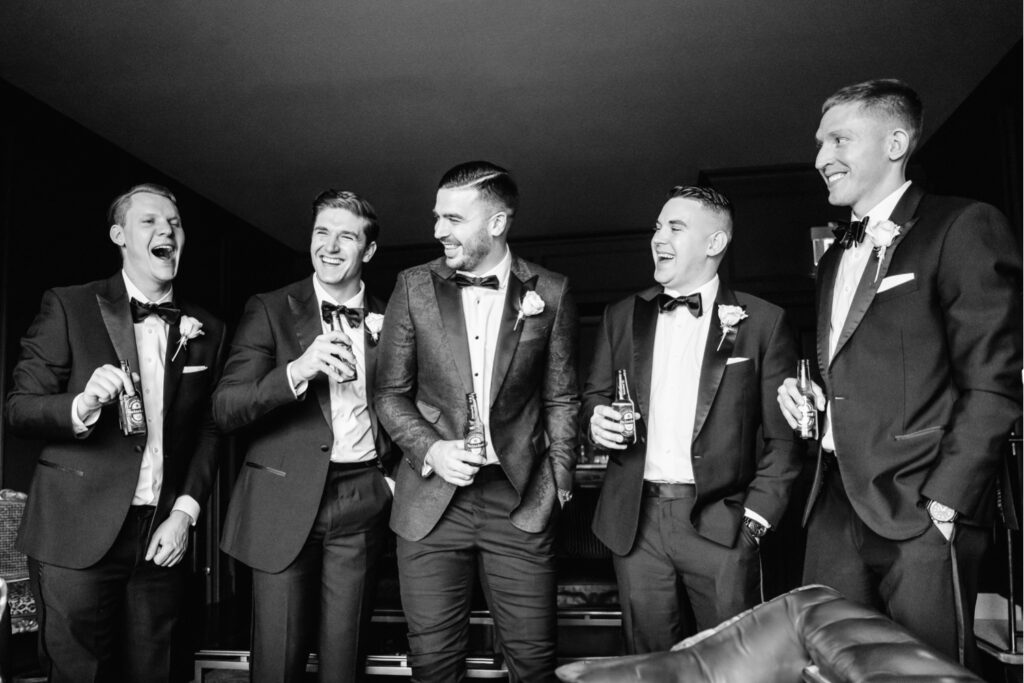 groom drinking with his groomsmen before his winter wedding