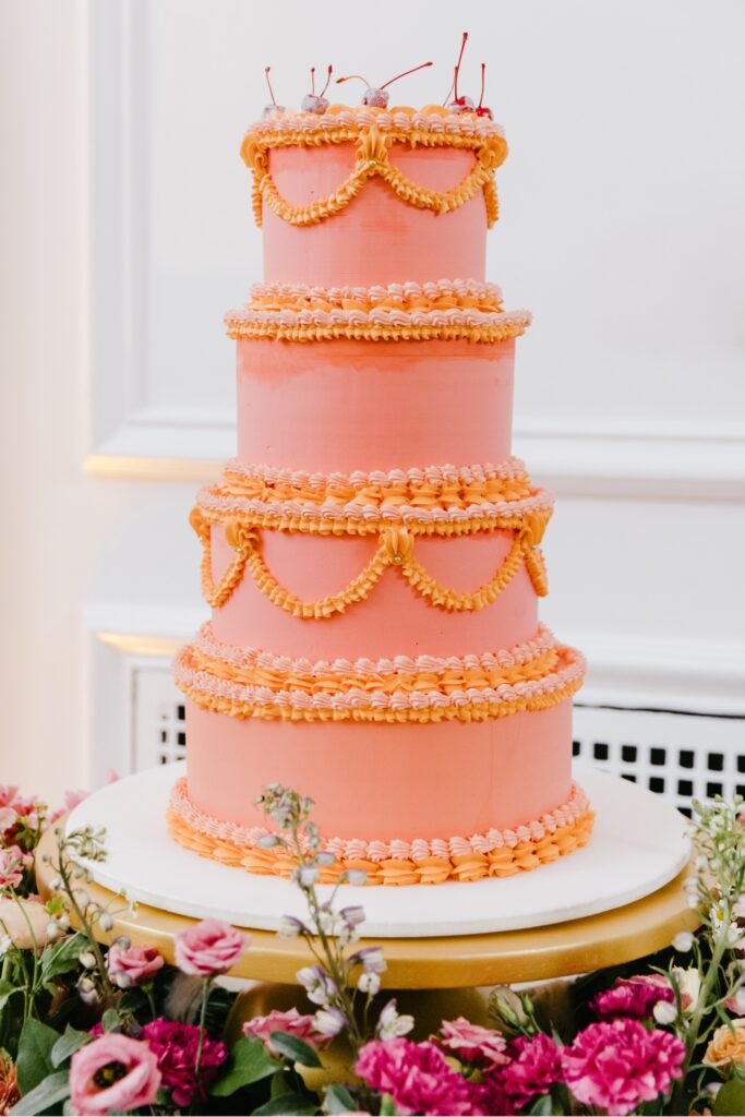 pink and orange 4 tier wedding cake topped by cherries