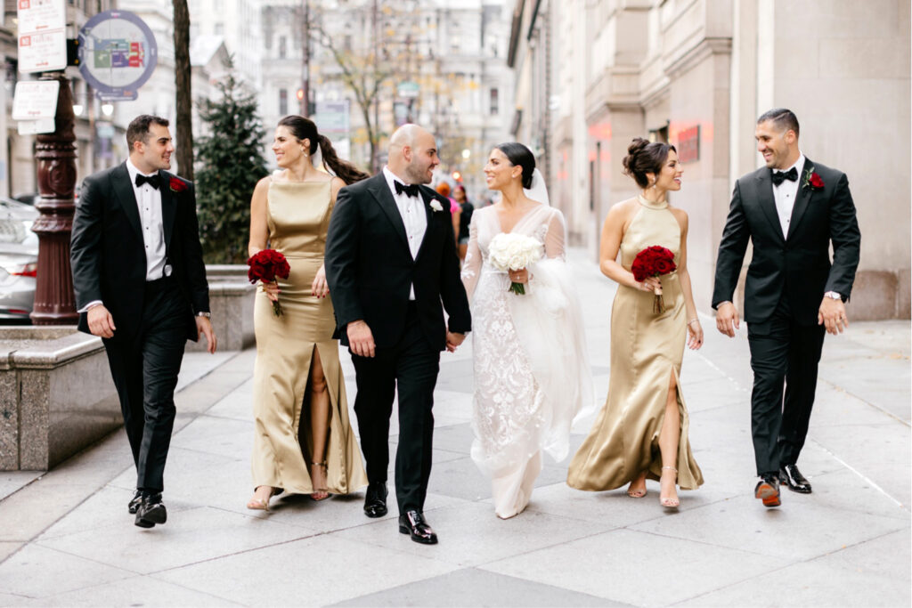 bridal party walking down broad & market streets in Philadelphia by Emily Wren Photography