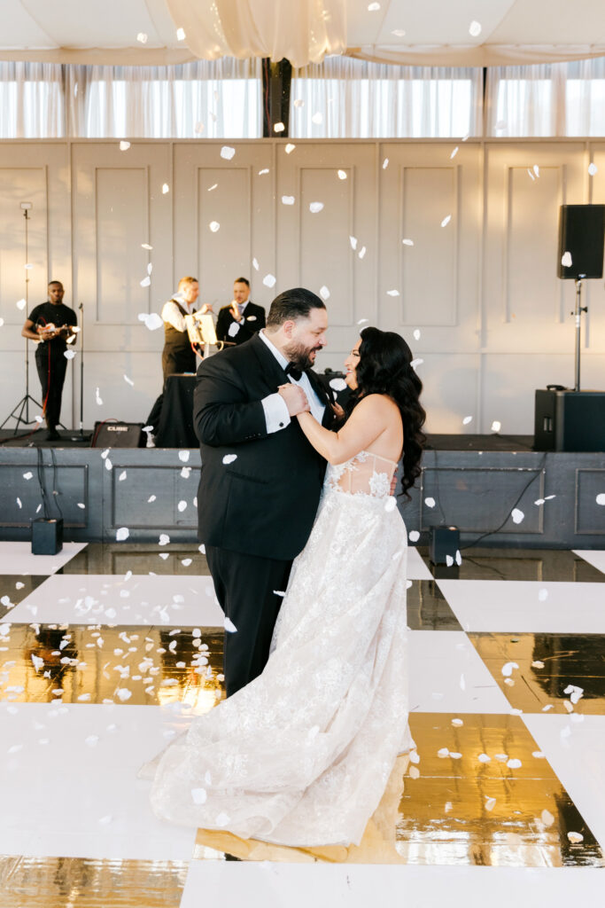 bride & grooms first dance as flower petals fall are thrown at Cescaphe's Philadelphia Water Works venue by Emily Wren Photography