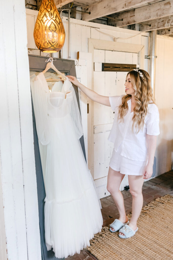 bride looking at her wedding gown before her summer garden wedding in Pennsylvania