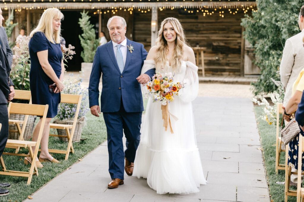 bride walking down the aisle at her outdoor summer wedding ceremony at Terrain at Styer's by Emily Wren Photography