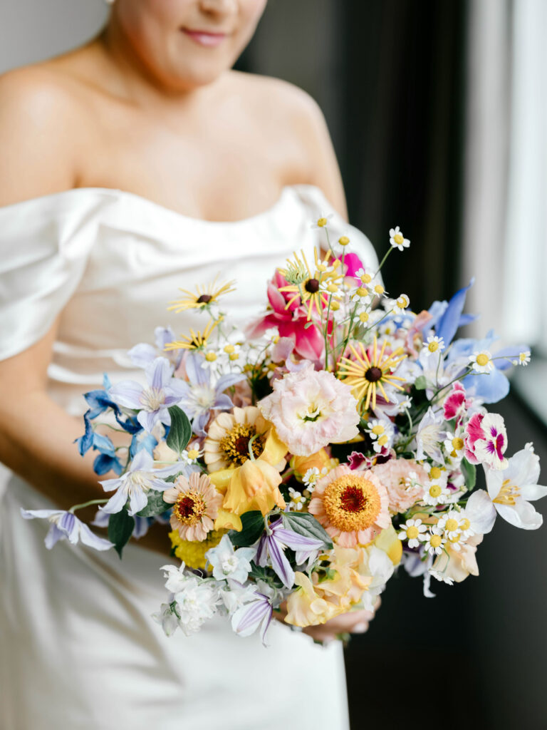 colorful spring bridal bouquet with orange, pink, blue & white flowers