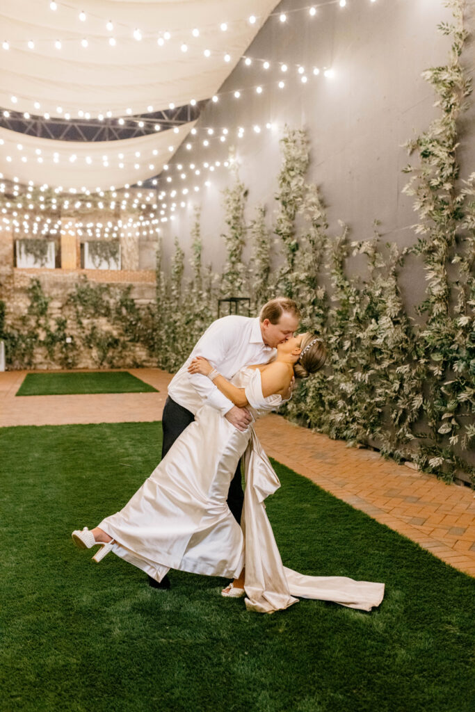 Bride & groom portrait under romantic string lights by Emily Wren Photography