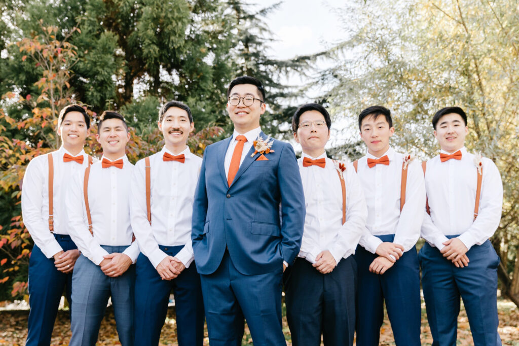 groom with groomsmen dressed in blue & orange on Fall wedding day in Pennsylvania