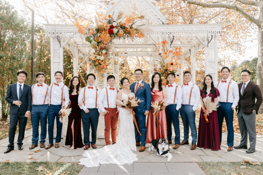 full bridal party dressed in burnt orange & blue for autumn wedding day at Terrain at Styer's by Emily Wren Photography