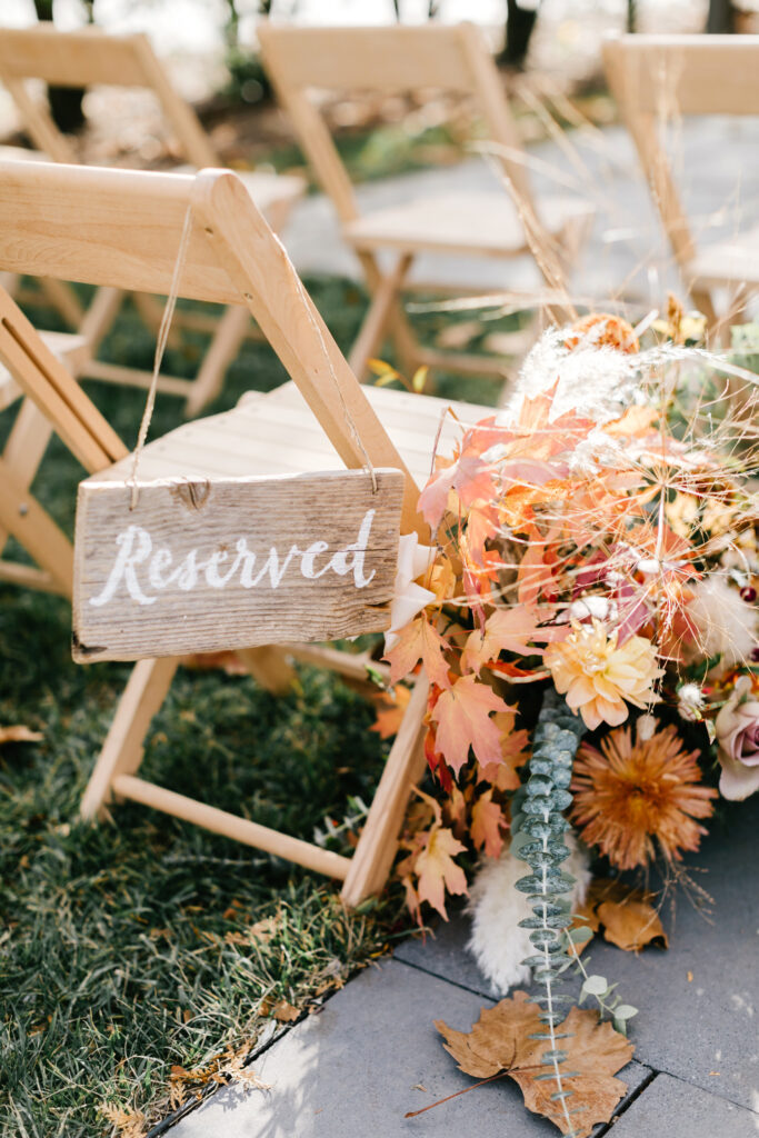 reserved wedding ceremony chair with fall foliage