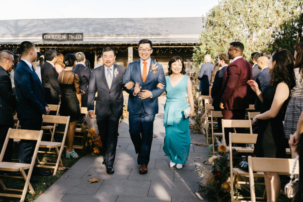 groom walking downt he aisle at Terrain wedding by Emily Wren Photography