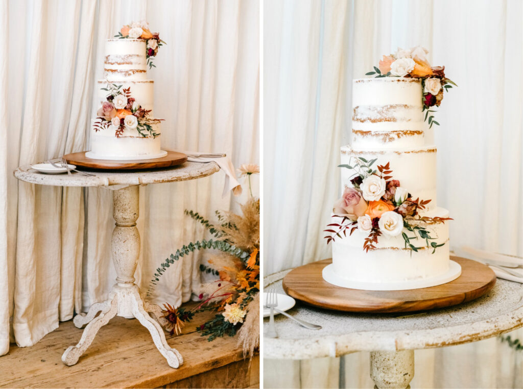 Nearly naked wedding cake decorate with fall foliage & orange and white flowers