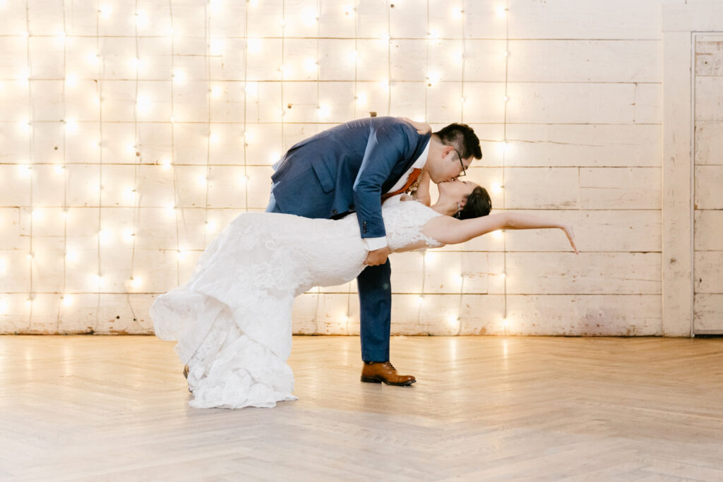 bride & grooms first dance in front of string light wall by Philadelphia wedding photographer Emily Wren Photography