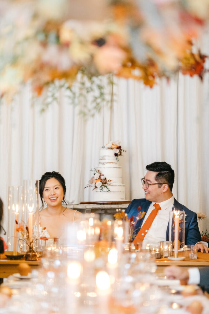 bride & groom at fall inspired sweetheart table by Emily Wren Photography