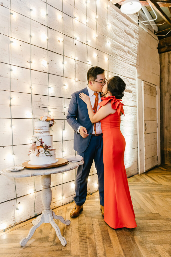 bride & groom cutting nearly their naked wedding cake by Emily Wren Photography