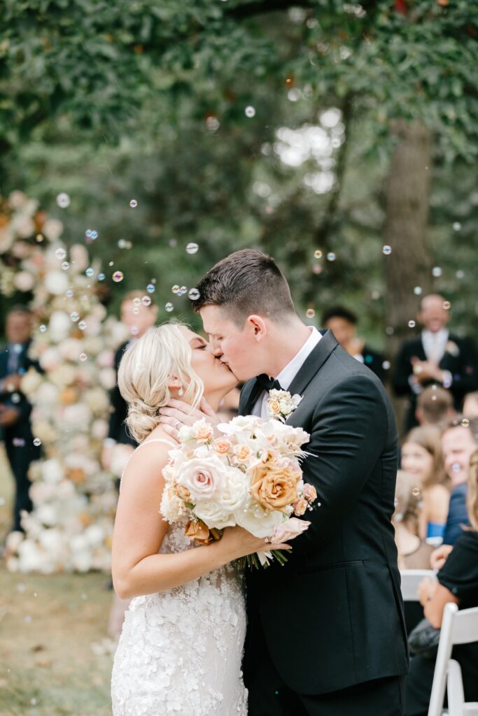 bride & groom exiting outdoor Glen Foerd wedding ceremony while guests blow bubbles