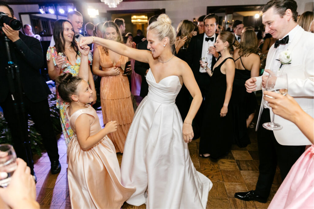 bride dancing with flower girl during wedding reception