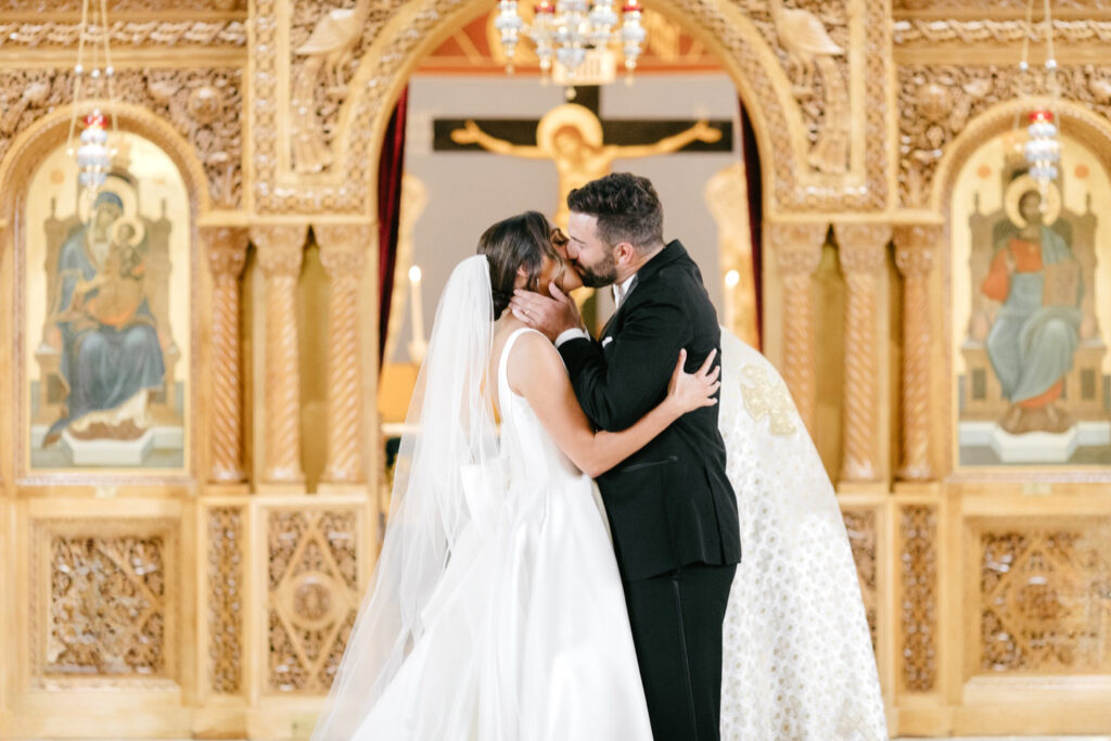 bride & grooms first kiss as married couple during church wedding ceremony in Philadelphia