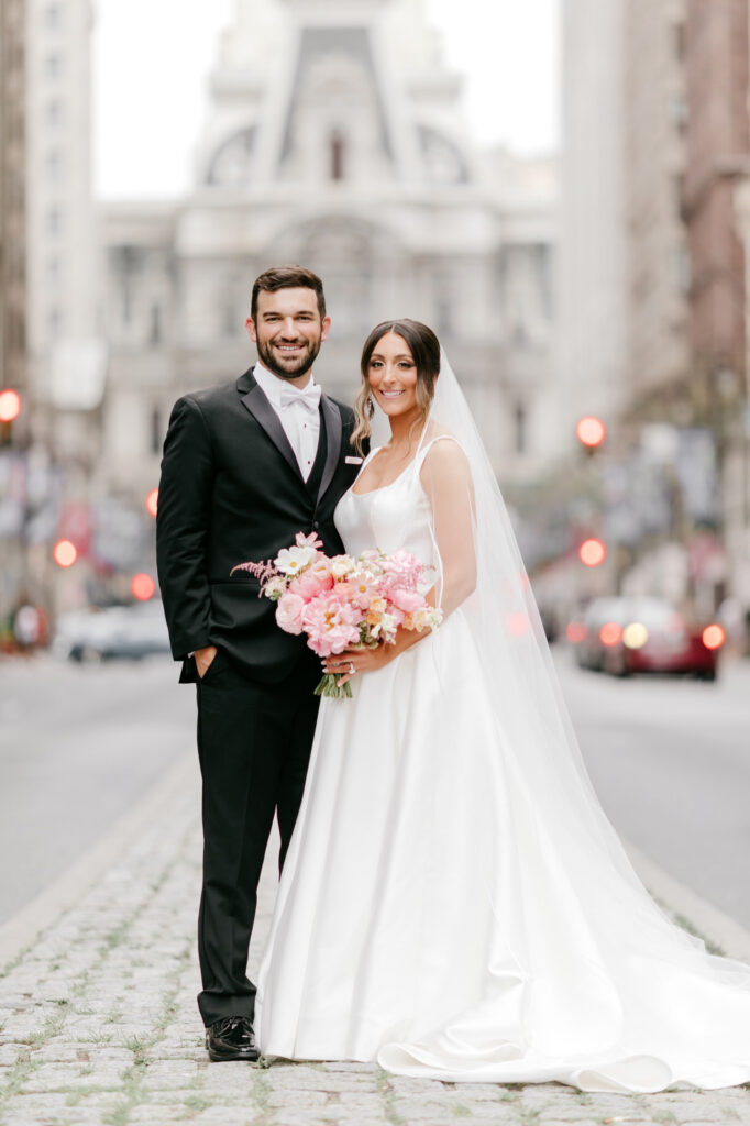 bride & groom on Broad Street in front of City Hall by Philadelphia wedding photographer Emily Wren Photography