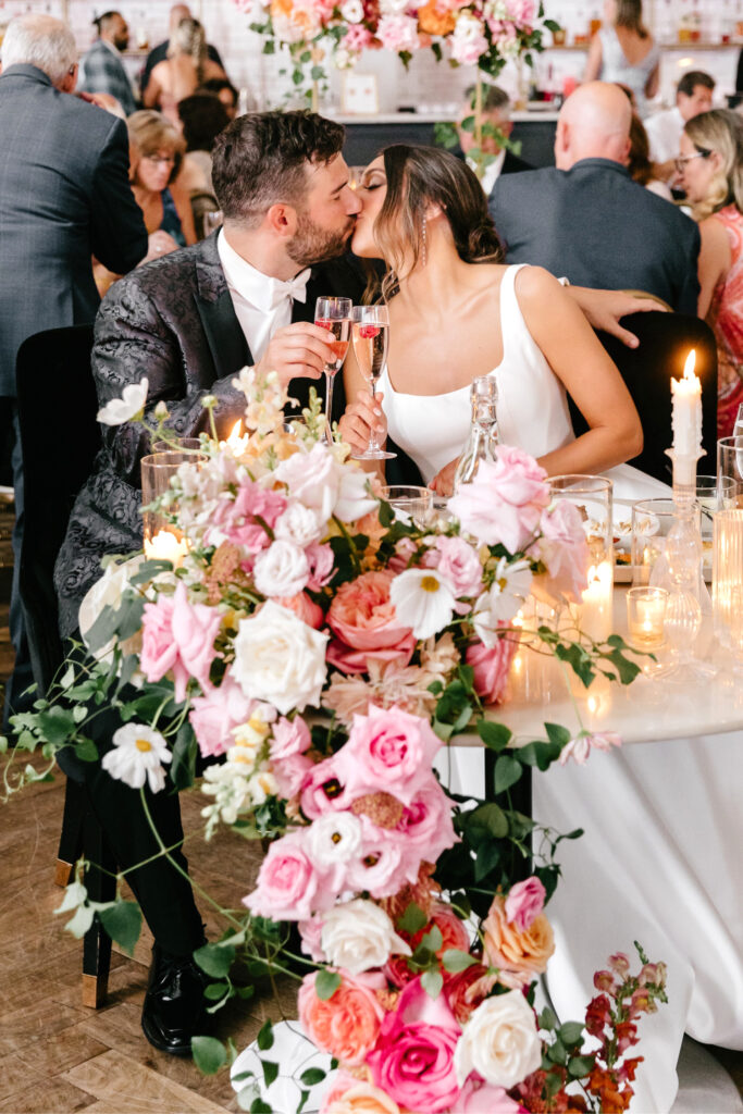 bride & groom at vibrant floral sweetheart table