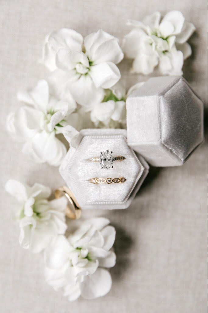 wedding and engagement wings surrounded by white flowers by Emily Wren Photography