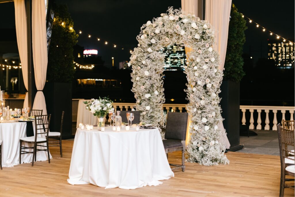 sweetheart table at Fall Cescpahe wedding reception at Water Works with white floral arch