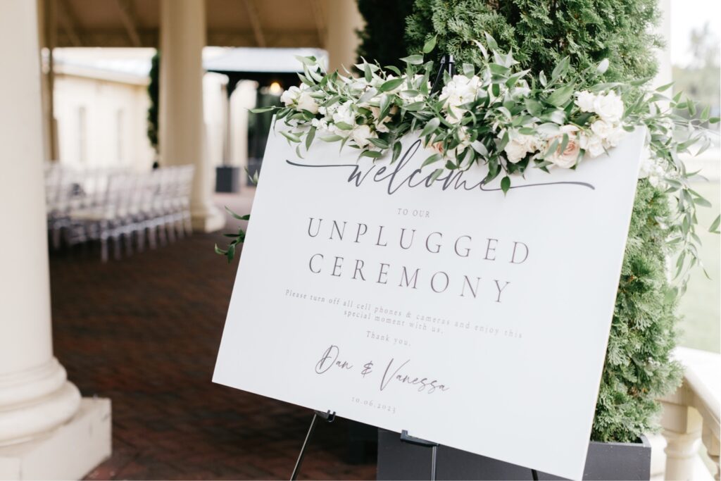 unplugged ceremony welcome sign with greenery by Emily Wren Photography