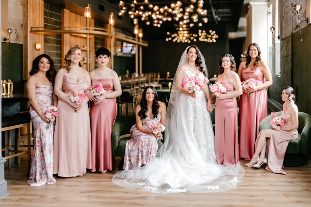 bride with her bridesmaids dressed in different shades of pink & rose bridesmaid dresses