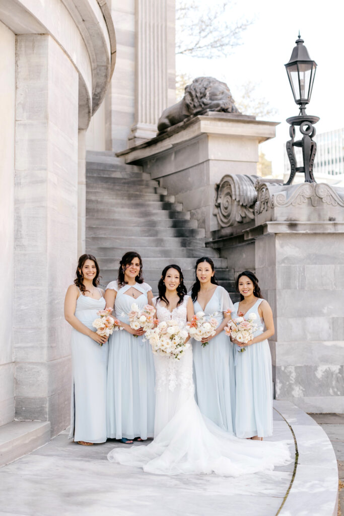 bride with her bridesmaids in light blue bridesmaid dresses for spring wedding