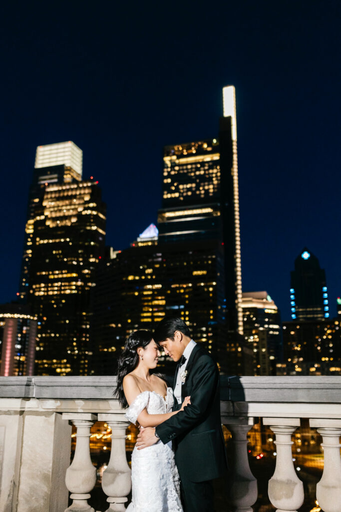 bride & groom portrait in front of the Philadelphia skyline at night
