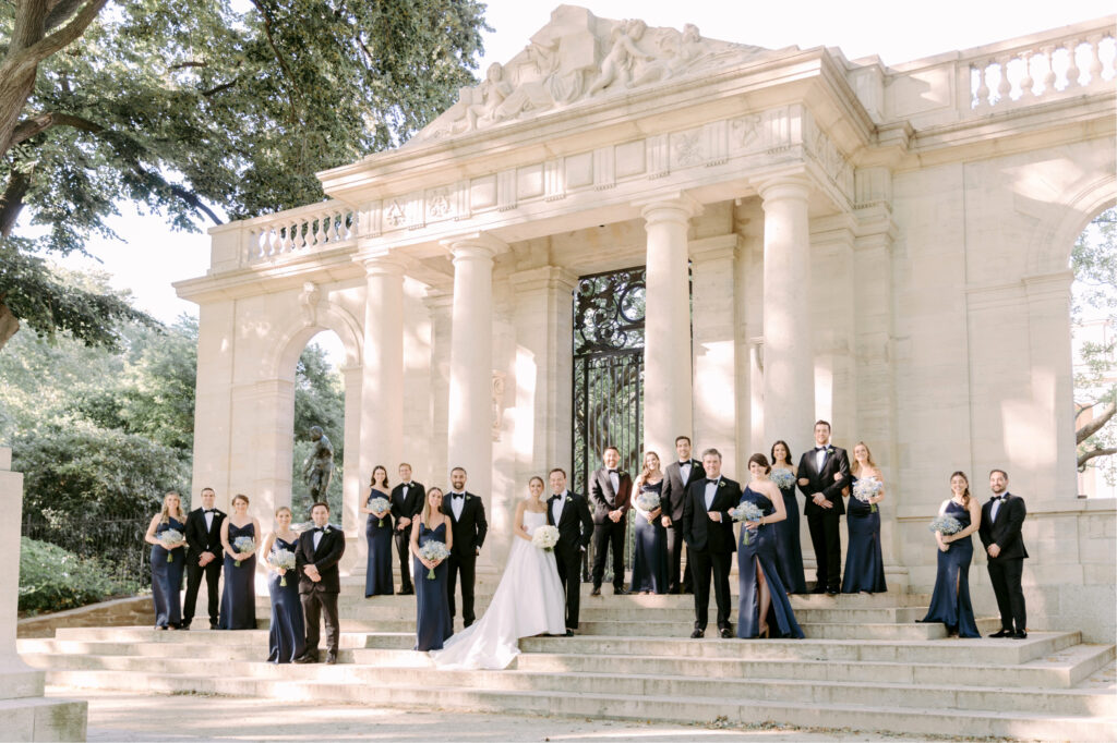 full bridal party dressed in black suits & navy blue bridesmaid dresses at the Rodin Museum in Philadelphia, Pennsylvania